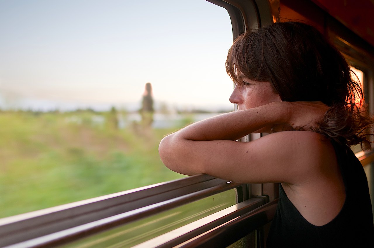 A fellow passenger looking off into the sunset on a train from Spain to France.