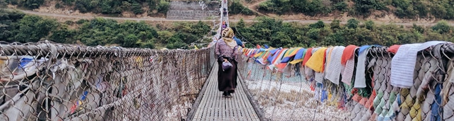 A man riding a bike on theseBhutanese bridge