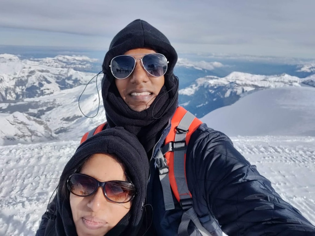 A couple posing in Europe with snow capped sorroundings