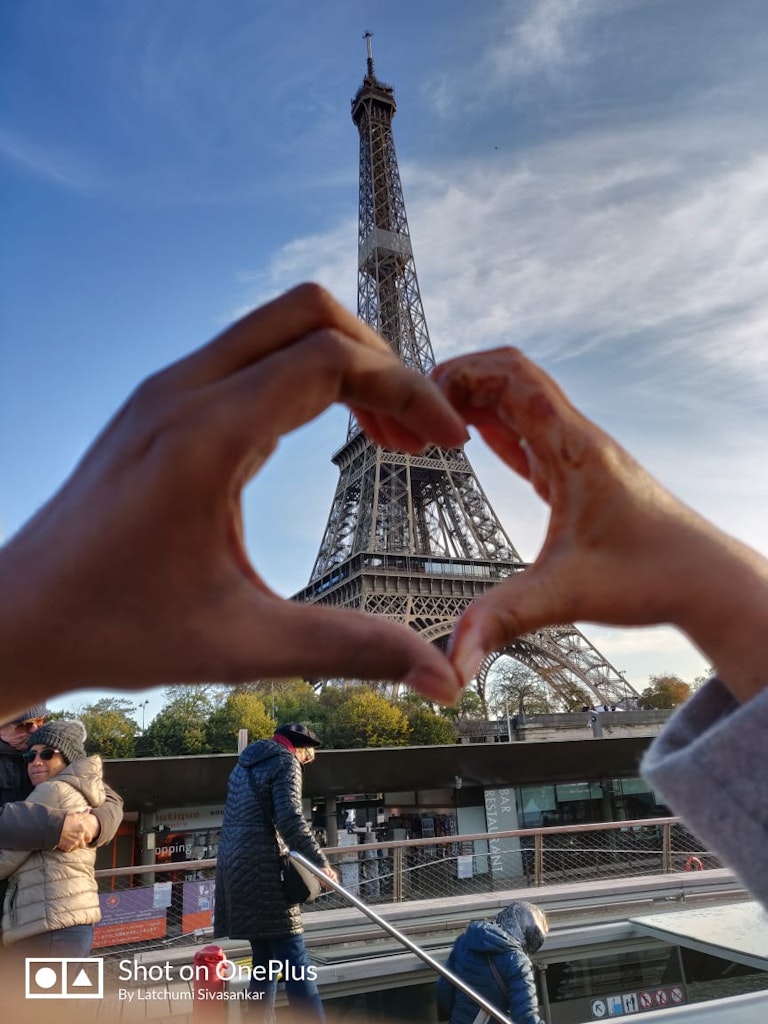 An amazing picture of a couple showing the symbol of love in Eiffel tower