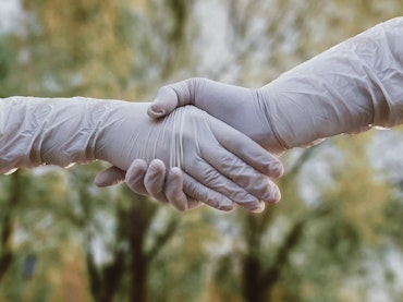 A couple holding hand covered in gloves.