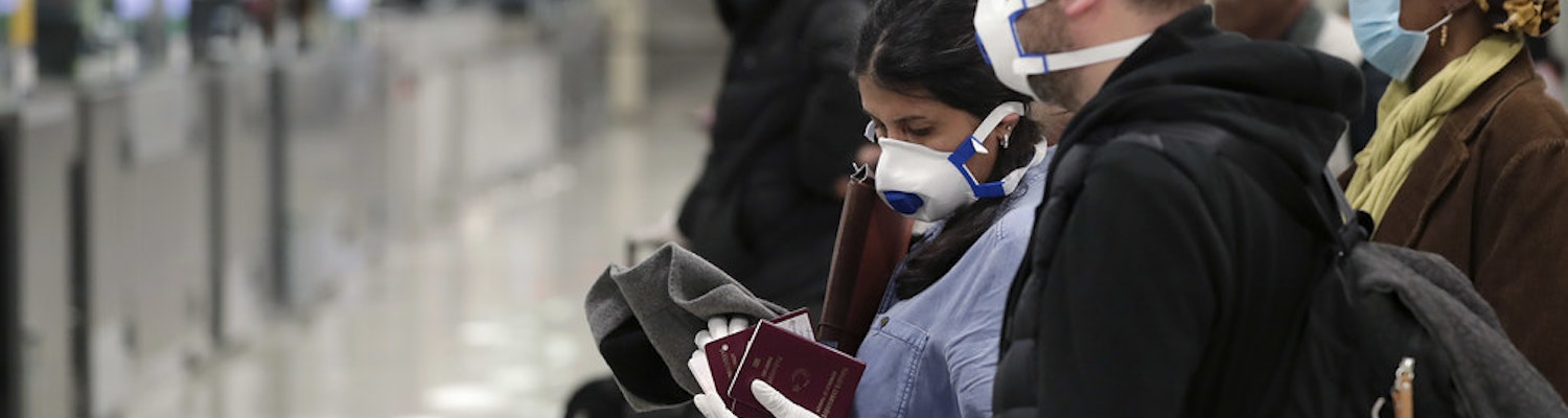 A picture of people waiting at the airport with masks covering their faces
