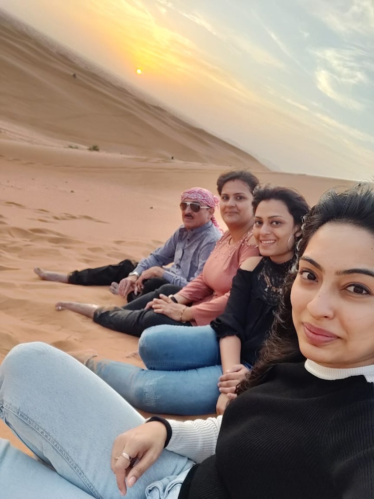 A group of people enjoy the sunset in the Desert Safari