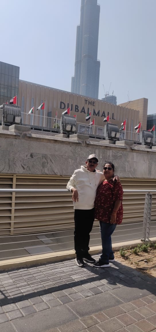 A couple posing for a picture in front of the Dubai Mall