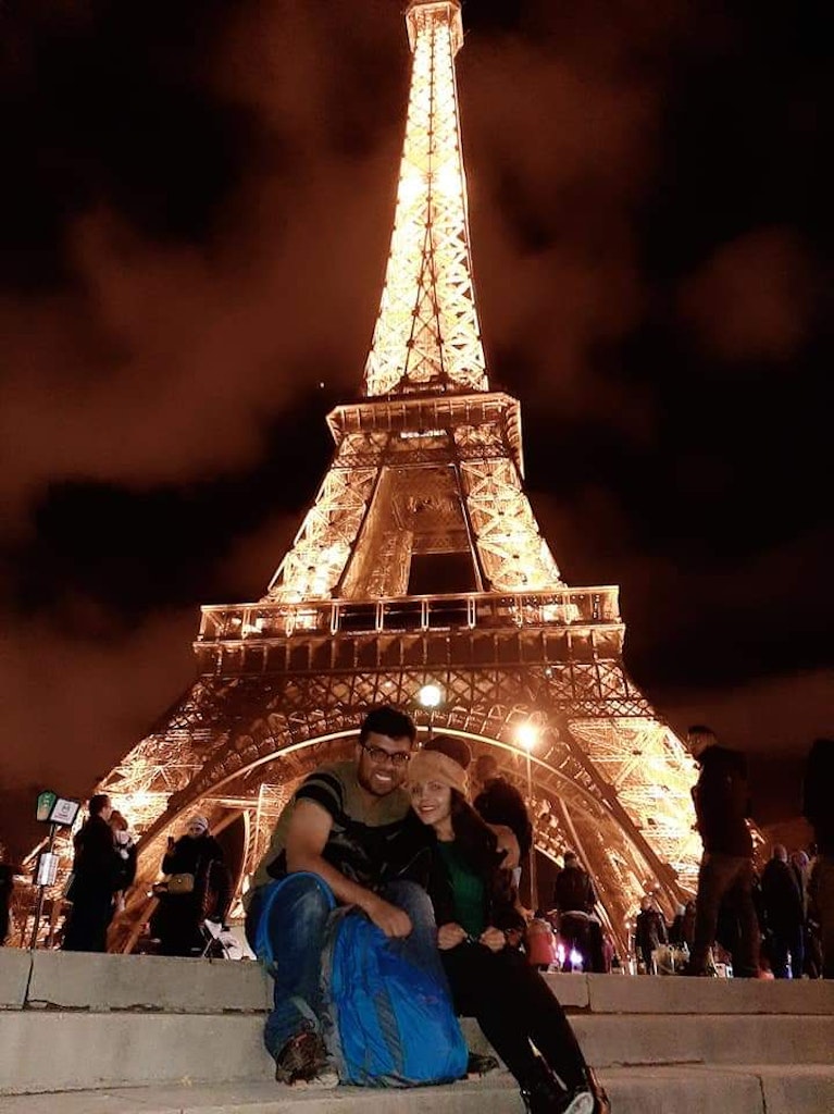 A beautiful picture of a couple at Eiffel tower in lights on their honeymoon vacation to Europe