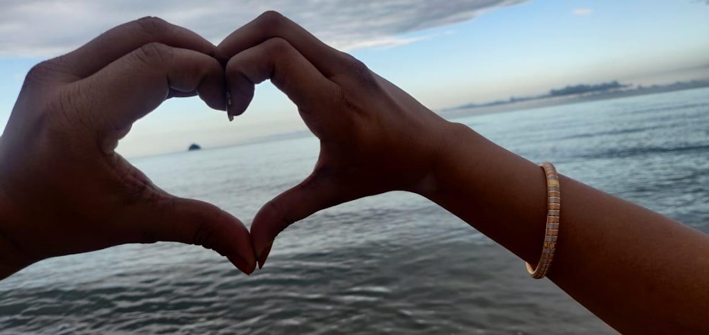 A couple showing the symbol of love on their honeymoon trip to Australia