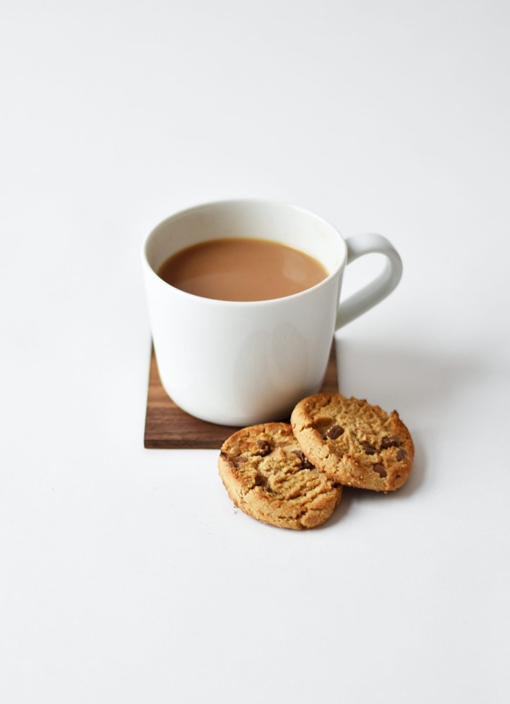 A cup of tea with 2 biscuits