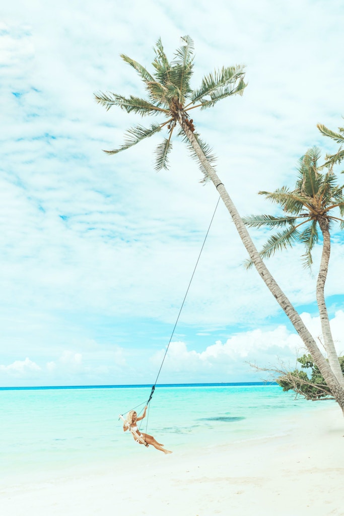 a girl swinging on the beach.