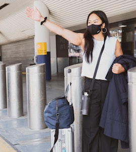 A woman wearing a mask in an airport.