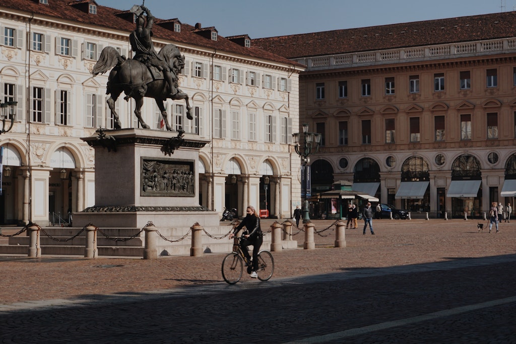 Woman riding a bike in Italian city, Torino, Italia